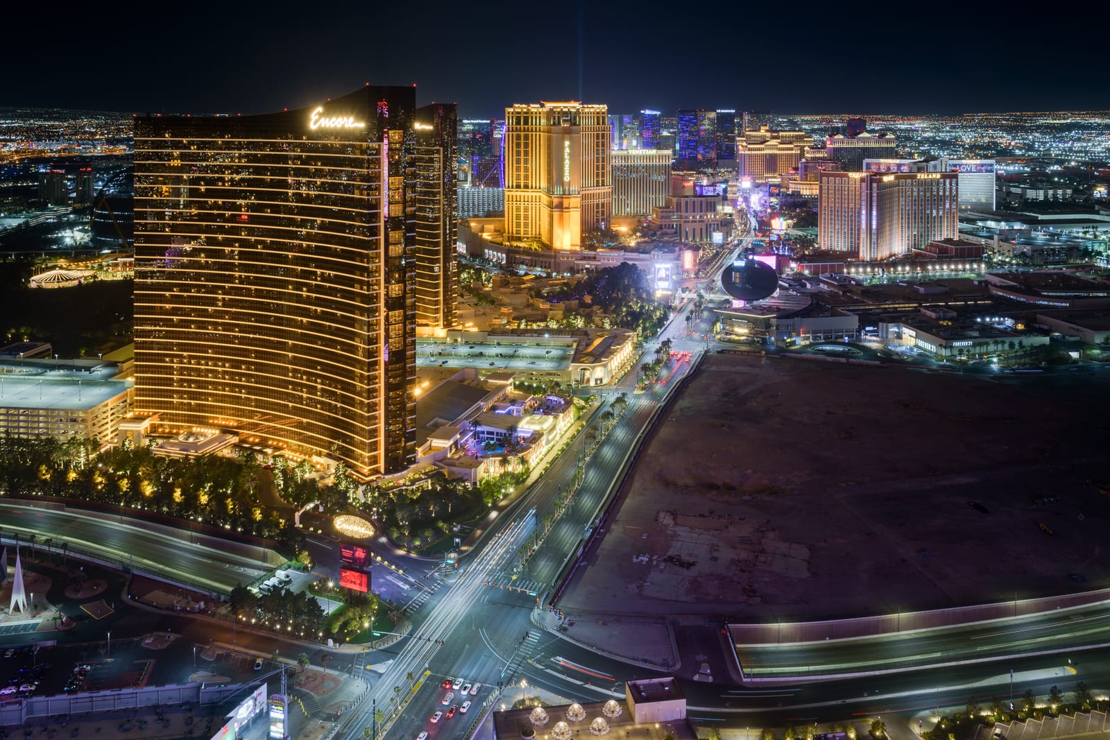 Aerial night view of the Las Vegas Strip with the Wynn and Encore towers in the foreground