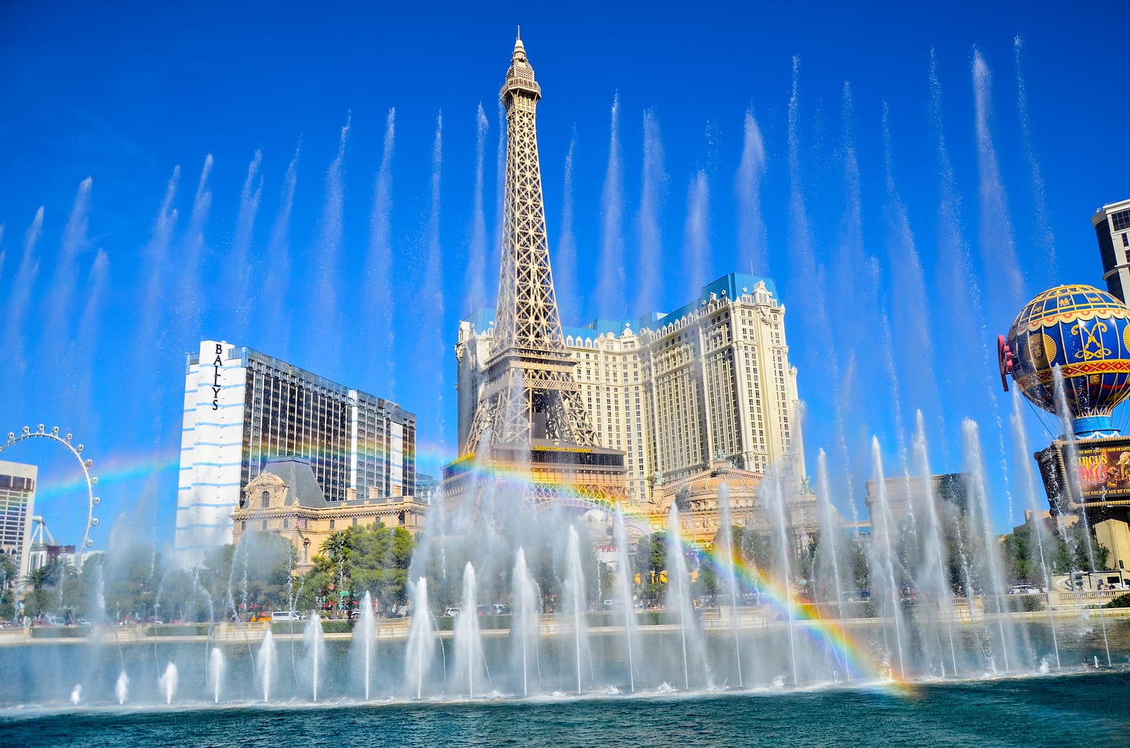 Fountains of Bellagio spraying water with the Paris Las Vegas Eiffel Tower behind on the Center Strip